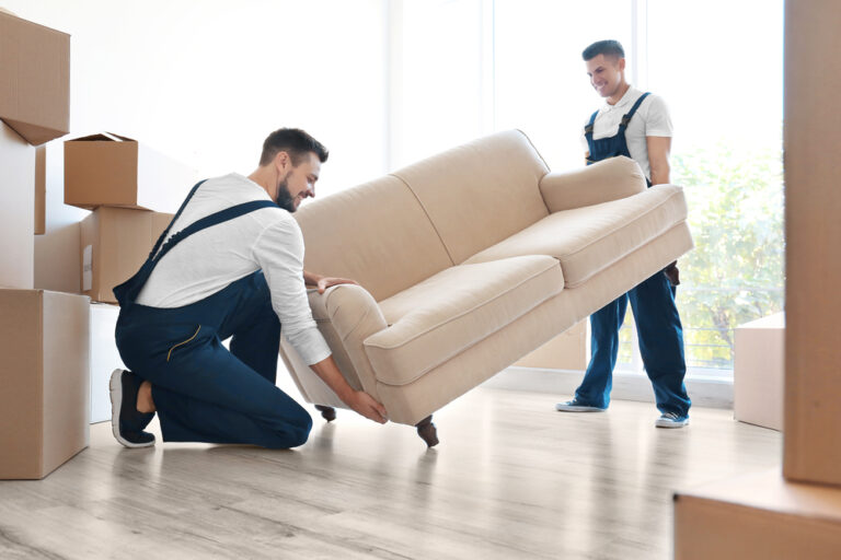 Two Scarborough movers lifting a couch.